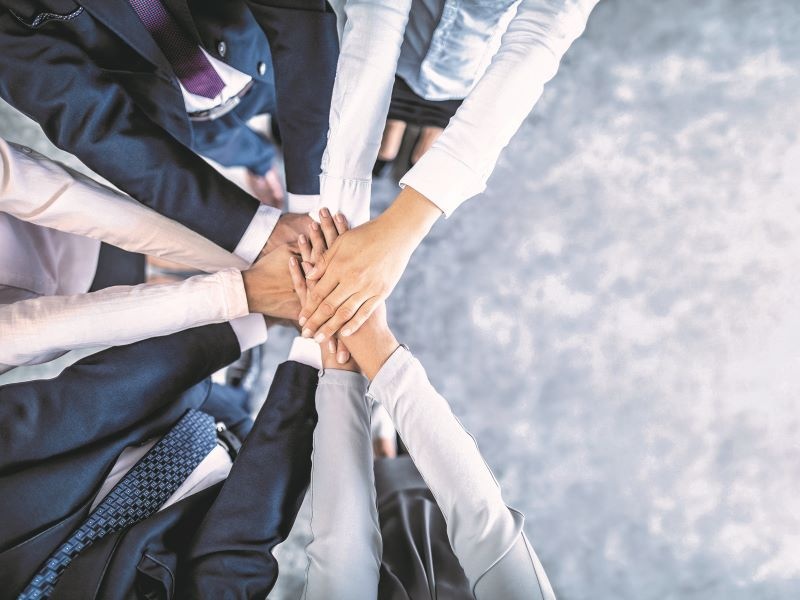hands of office people together in a team huddle