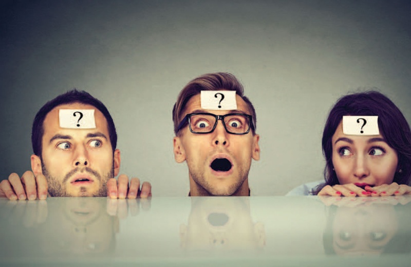 stock photo of three people with question mark stickers on their foreheads looking confused