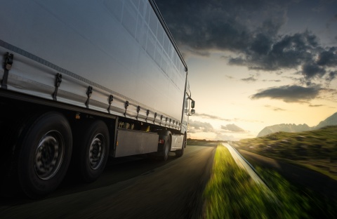 truck driving toward sunset