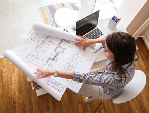 woman looking at blueprints